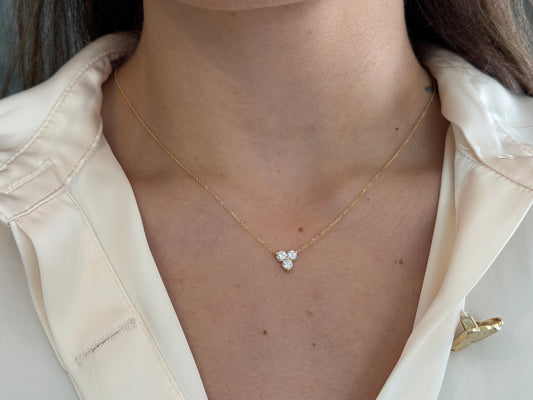 14k yellow gold necklace with a three-stone pendant of round brilliant cut diamonds on a model