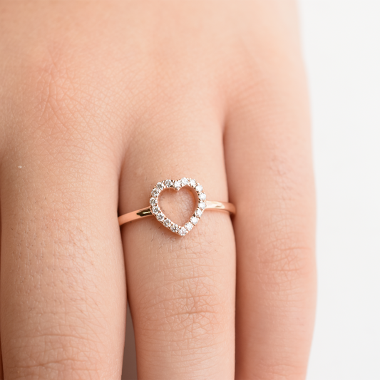 A 14k yellow gold diamond heart ring with a small heart-shaped diamond in the center, set on a plain band.