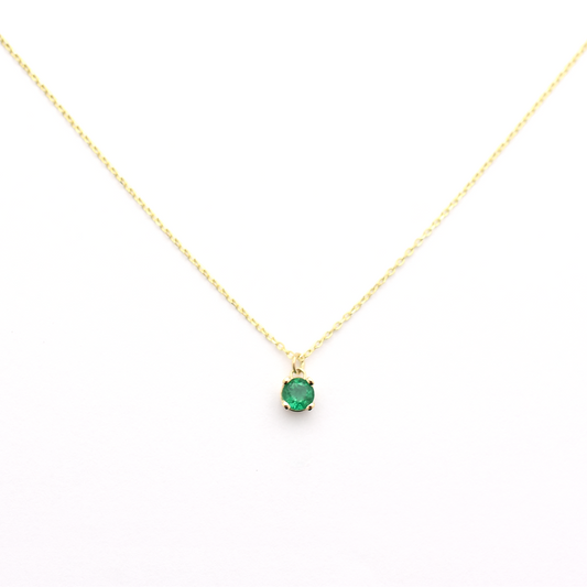 A 14k gold necklace with a single emerald stone pendant.