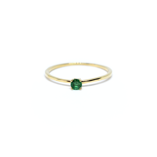 A 14K gold round emerald ring with a single emerald stone on a white background.