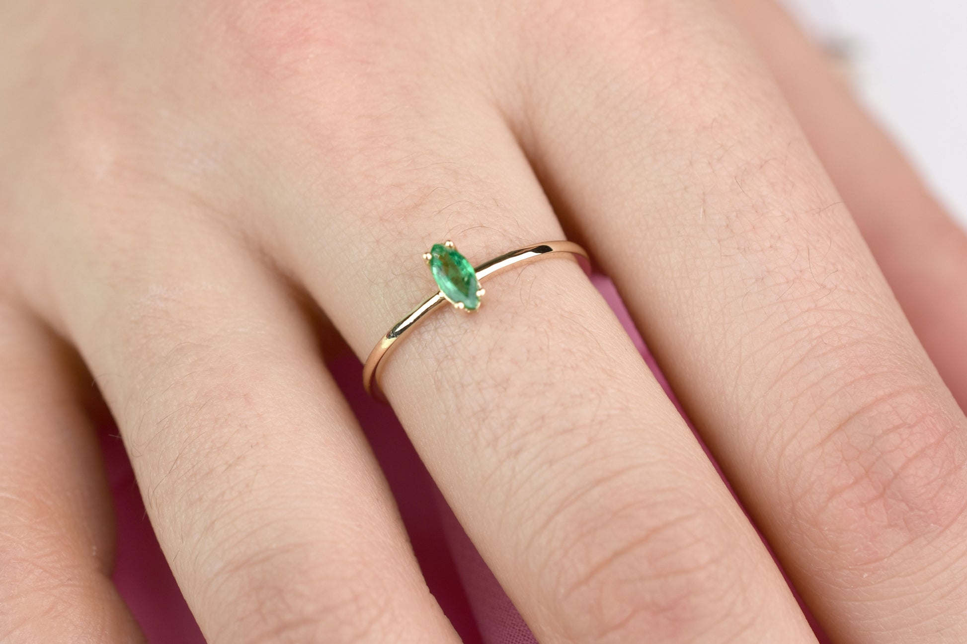 14k gold marquise shaped natural emerald set in a 4 prong setting 